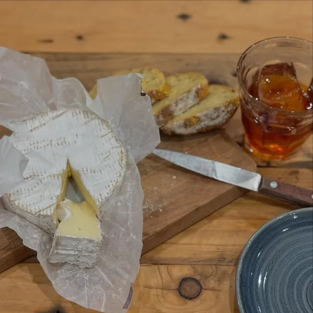 Camembert de Normandie et verre de cidre sur une planche